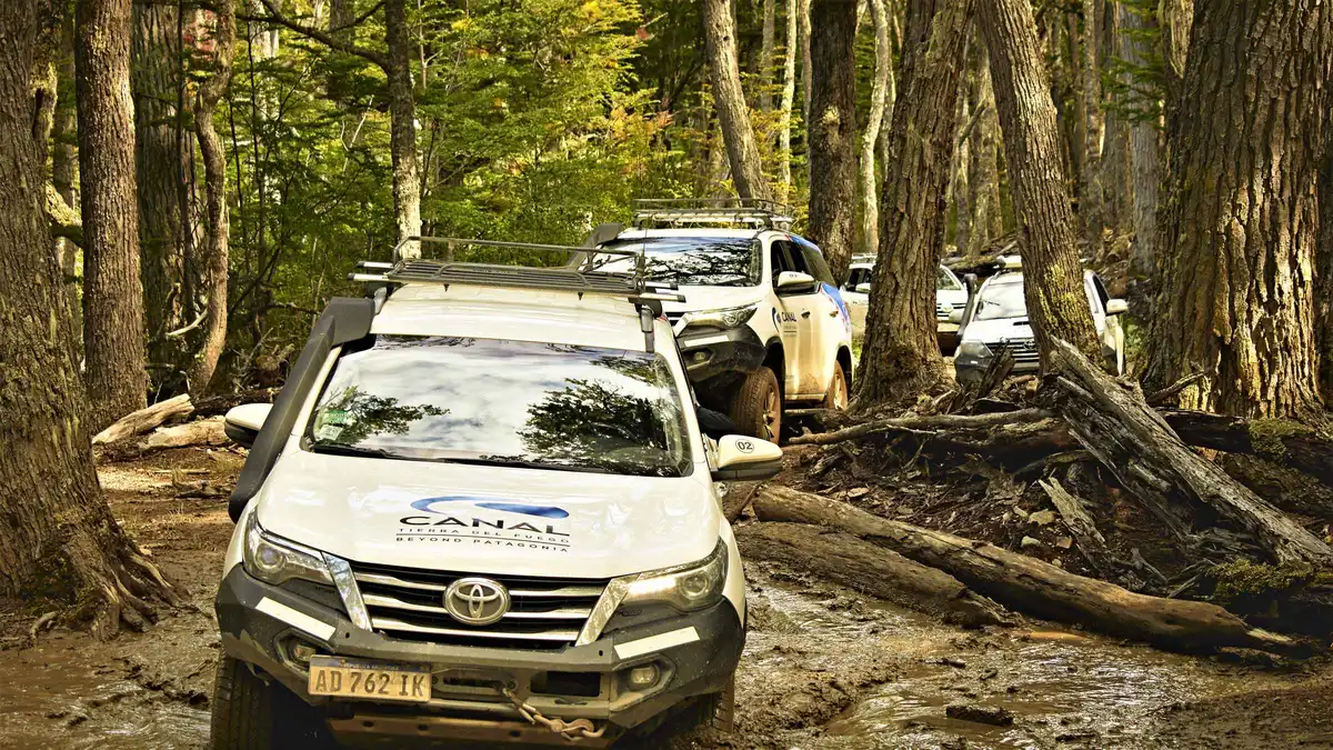 Off-road vehicle fording a shallow river on the lakes route north of Ushuaia, Tierra del Fuego, Argentina