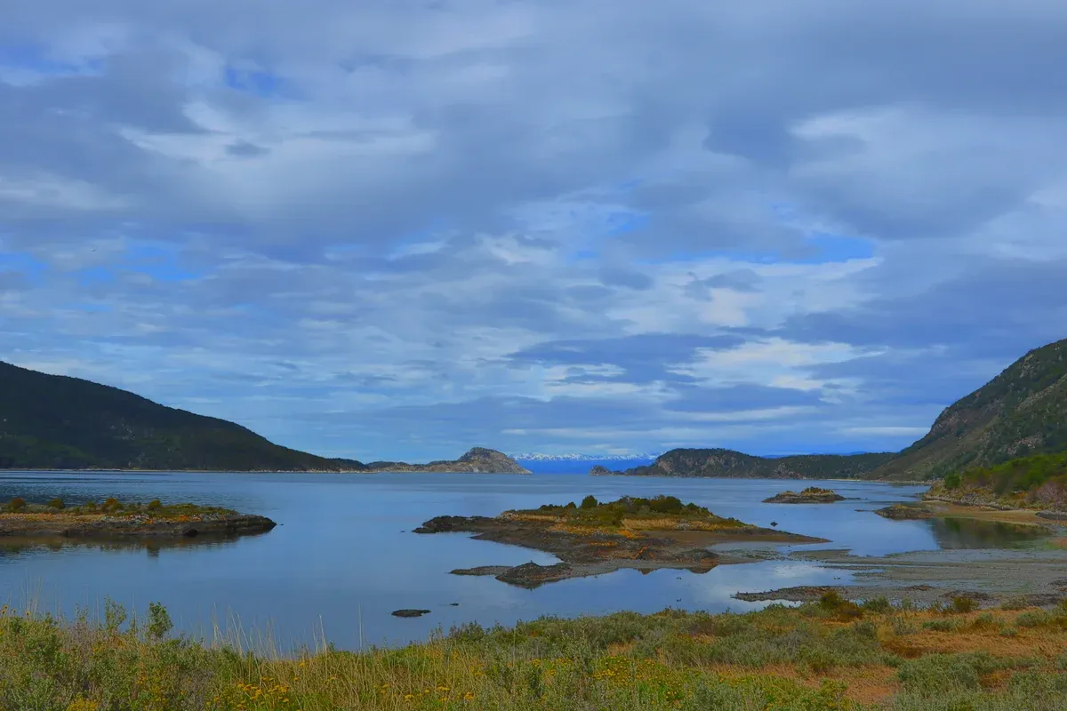 The islands and forested shoreline of Lapataia Bay under a cloudy sky in Tierra del Fuego National Park near Ushuaia, Argentina